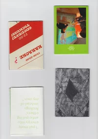 Vier kleine Karten liegen rasterförmig auf einer flachen Fläche; alle Karten sind verkehrt herum angeordnet. Jede Karte hat unterschiedliche Farben und Designs, darunter Text, ein Schwarzweißbild und ein Foto von Personen, die auf eine Tafel schreiben.